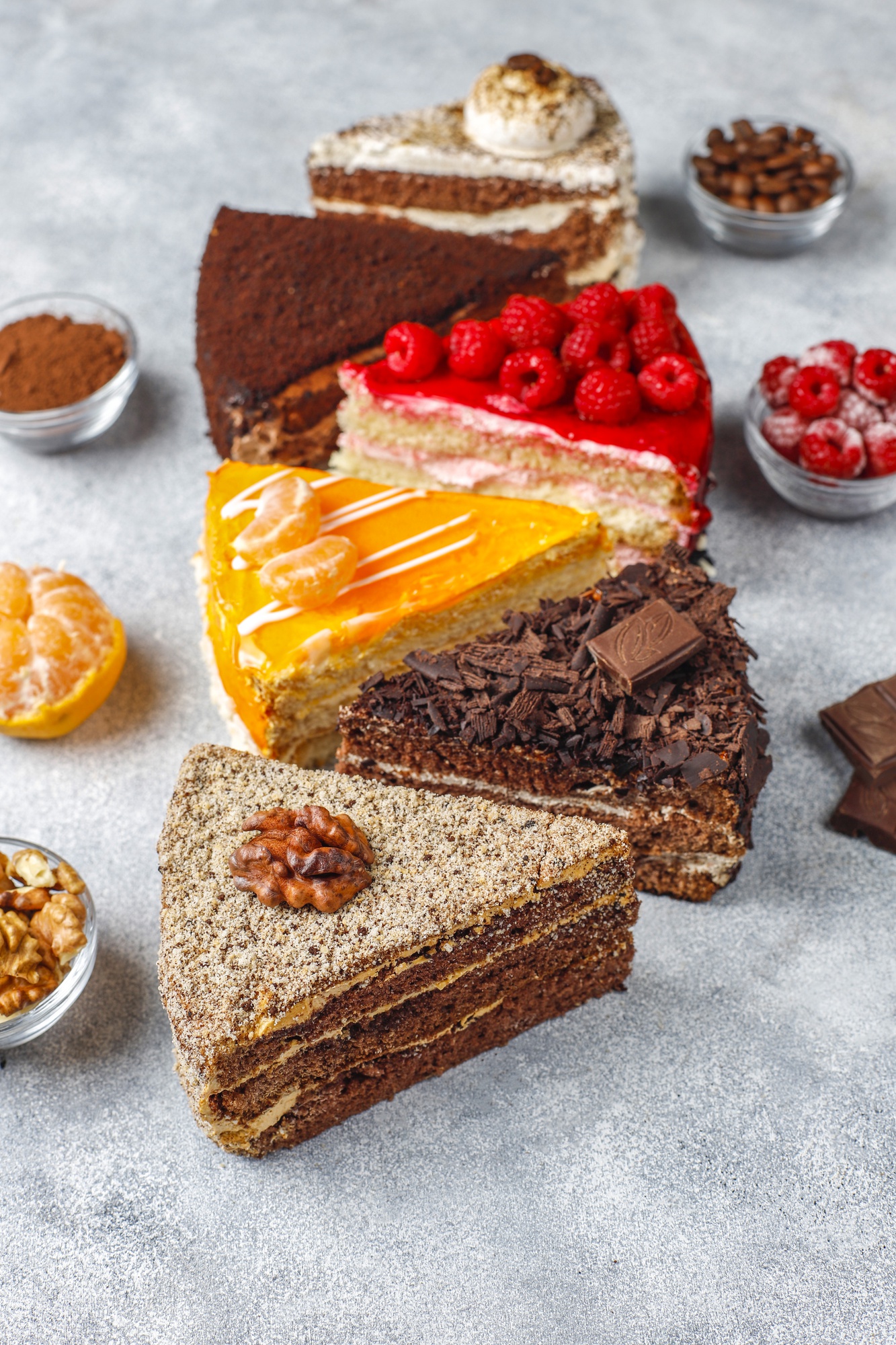 An assortment of colorful vegan cake slices, showcasing diverse flavors and textures, made using egg substitutes like flaxseeds and bananas.