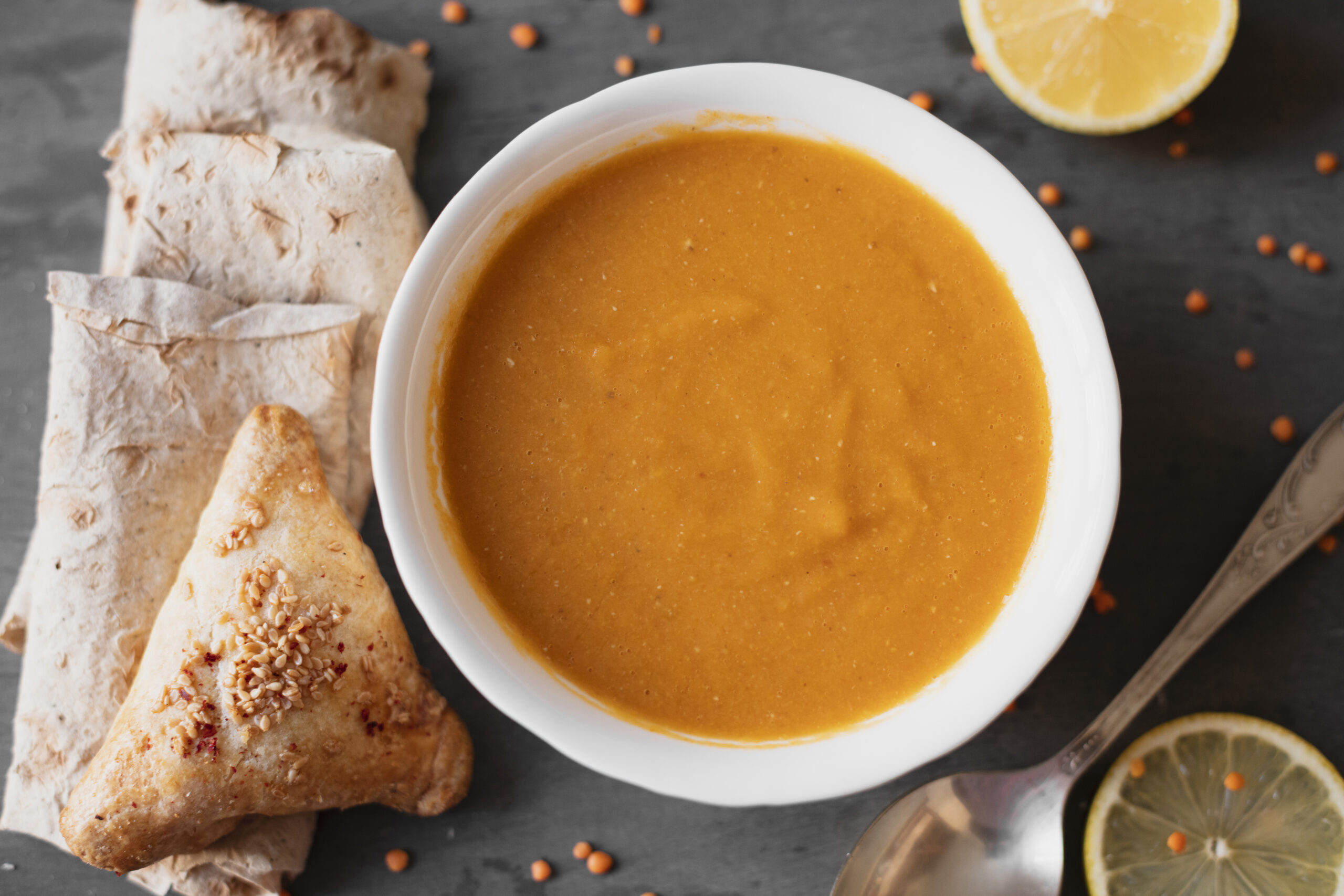 A vibrant bowl of vegan pureed soup with a creamy peanut variation, garnished with fresh herbs and crushed peanuts, perfect for a healthy meal.